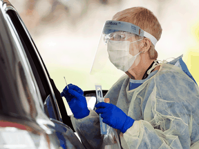 Health-care workers do testing at a drive-thru COVID-19 assessment centre at the Etobicoke General Hospital in Toronto.