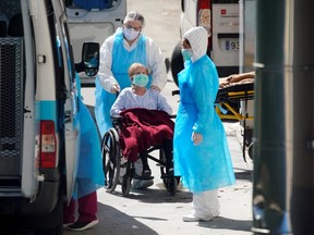 Ambulance workers push a wheelchair with a patient at a nursing home during the coronavirus disease (COVID-19) outbreak in Leganes Madrid, near Madrid, Spain, April 2, 2020. REUTERS/Juan Medina/File Photo ORG XMIT: FW1