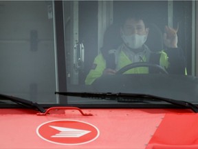 A Canada Post employee wears a mask on a delivery route.