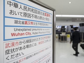 A passenger walks past a notice for  passengers from Wuhan, China displayed near a quarantine station at Narita airport on January 17, 2020 in Narita, Japan.  (Photo by Tomohiro Ohsumi/Getty Images)