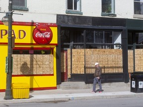 The closed Prince Albert's Diner and neighbouring stores have had to install particle board in their windows because of damage along Richmond Street. (MIKE HENSEN, The London Free Press)