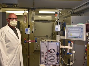 Chris McIntyre, a nephrologist and Lawson Health Research Institute scientist, stands with the modified dialysis machine that London researchers are using to treat critically ill COVID-19 patients. The machine has been refitted to capture, treat and release white blood cells in a bid to reduce the life-threatening inflammation triggered by the virus. (Supplied/Lawson Health Research Institute)