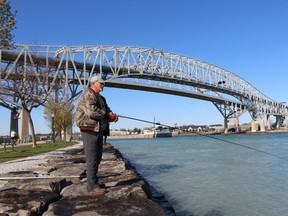 Lou DeBrum of Sarnia casts a line into the St. Clair River near the Blue Water Bridge, which carries vehicles crossing between Michigan and Ontario.