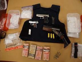 Police seized two loaded handguns, a sawed-off shotgun, conducted energy weapon, drugs and cash during a series of searches in London, Kitchener and Hanover on Wednesday. Five people are charged. (London police photo)