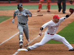 SK Wyverns infielder Jamie Romak, right, forces out Hanwha Eagles' Ha Ju-suk at first base in the second inning during the opening game for South Korea's new baseball season at Munhak Baseball Stadium in Incheon on Tuesday. South Korea's professional sport returned to action after the coronavirus shutdown, while football and golf will soon follow suit in a ray of hope for suspended competitions worldwide. (Jung Yeon-je/AFP)