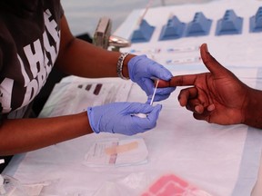 In this file photo a man takes a free HIV test during the Harlem Pride parade in New York City on June 29, 2019.(Photo by Kena Betancur / AFP)