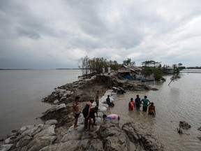 Volunteers and residents work to repair a damaged dam following the landfall of cyclone Amphan in Burigoalini on May 21, 2020. - At least 84 people died as the fiercest cyclone to hit parts of Bangladesh and eastern India this century sent trees flying and flattened houses, with millions crammed into shelters despite the risk of coronavirus. (Photo by Munir uz Zaman / AFP)