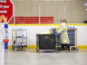 A health care worker transports supplies inside Oakridge Arena which has been transformed into a coronavirus assessment centre in London, Ont. on Tuesday March 17, 2020.  (Derek Ruttan/The London Free Press)