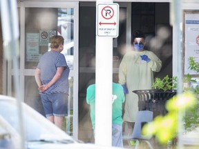 People wait outside the Carling Heights Optimist Community Centre COVID-19 assessment centre in London, Ont. on Tuesday May 26, 2020. Derek Ruttan/The London Free Press/Postmedia Network