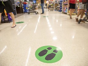 Distancing decals have been placed two metres apart on the floor of the Sobeys Extra grocery store on Wonderland Road in London. (Derek Ruttan/The London Free Press)