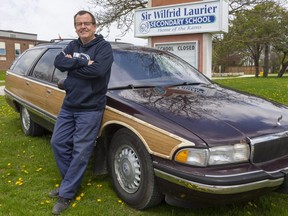 Jeff Ste. Marie, with his beloved Buick woodie station wagon, poses proudly in front of Sir Wilfrid Laurier secondary school, where he has taught shop and coached swimming for 30 years and is now retiring. (Mike Hensen/The London Free Press)