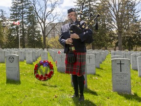 Patrick Potter plays bagpipes in Woodland Cemetery on Friday, May 8, 2020 to commemorate the 75th anniversary of the allies Victory in Europe VE-Day.  Potter started and finished with When the Battle's O'er, and also played Amazing Grace, Green Hills of Tyrol, and Goin' Home. (Mike Hensen/The London Free Press)