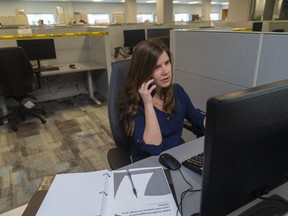 Julie Frederick, a case and contact investigator for the Middlesex-London Health Unit works the phones Thursday, May 14, 2020 in the new health unit offices where every other desk is taped off.  (Mike Hensen/The London Free Press)