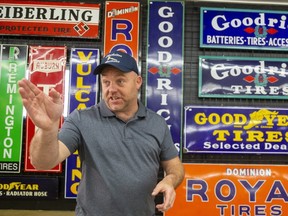 Mike Shackelton of Shackelton Auctions misses the fun of live auctioning but says that even before the COVID-19 pandemic, online auctions were growing, and now even more so. Shackelton was showing off his chops in front of some of their antique automobile signage at their offices near Springfield, Ont.  (Mike Hensen/The London Free Press)