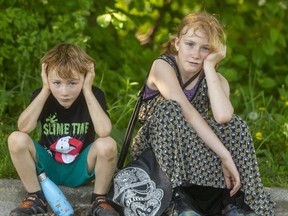 Kasper Desparois, 7, and his sister Astrid, 9, of London sit in the shade to cool off after running around Thames Park in the heat Tuesday.  Cooler temperatures are expected by Friday. (MIKE HENSEN, The London Free Press)