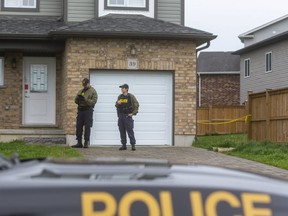 OPP investigators stand outside 39 Leesboro Trail in Thorndale, northeast of London, where a body was found Tuesday.  (Mike Hensen/The London Free Press)