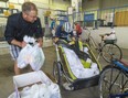 RBC Centre chef David Van Eldik carries a box of bagged lunches to the trailer of 17-year-old Wesley Hill of London on Friday to deliver to the homeless in London. The lunches are made by Van Eldik's kitchen in the convention centre using funding in part from the London Food Bank. (Mike Hensen/The London Free Press)