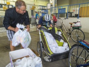 RBC Centre chef David Van Eldik carries a box of bagged lunches to the trailer of 17-year-old Wesley Hill of London on Friday to deliver to the homeless in London. The lunches are made by Van Eldik's kitchen in the convention centre using funding in part from the London Food Bank. (Mike Hensen/The London Free Press)