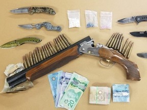 London police seized a sawed-off shotgun, prohibited knives, ammunition, drugs and cash from a Mornington Avenue home Wednesday. Two people face drug and weapons charges. (Supplied)