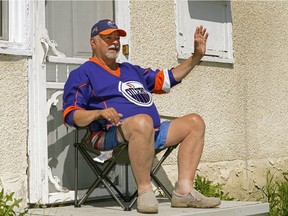 Rolland Sarasin waves to motorists and pedestrians from the front entrance of his home on 124 Street near 105 Avenue in Edmonton on Tuesday, June 2, 2020. He is a retail store employee who was laid off in March when the coronavirus pandemic hit but is now back at work. He spends hours everyday being social by waving at everyone passing by his home.