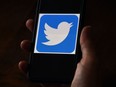 In this file illustration photo taken on May 27, 2020 a Twitter logo is displayed on a mobile phone in Arlington, Virginia.