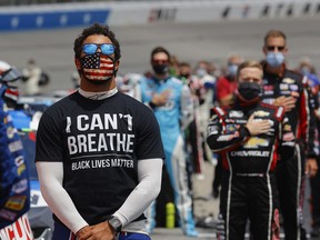 Bubba Wallace, driver of the #43 McDonald's Chevrolet, wears a "I Can't Breathe — Black Lives Matter" T-shirt under his fire suit in solidarity with protesters around the world taking to the streets after the death of George Floyd on May 25 while in the custody of Minneapolis, Minnesota police, stands during the national anthem prior to the NASCAR Cup Series Folds of Honor QuikTrip 500 at Atlanta Motor Speedway on June 07, 2020 in Hampton, Georgia.