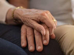 An elderly couple holding hands.