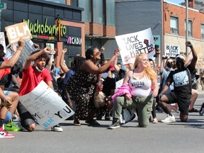 Demonstrators take a knee a knee at the corner of Richmond and Oxford streets on Saturday, June 6, 2020, during the Black Lives Matter rally in London. DALE CARRUTHERS / THE LONDON FREE PRESS