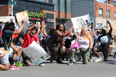 Demonstrators take a knee a knee at the corner of Richmond and Oxford streets on Saturday, June 6, 2020, during the Black Lives Matter rally in London. DALE CARRUTHERS / THE LONDON FREE PRESS