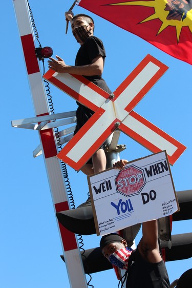 Two demonstrators scaled a railway light on Talbot Street during the Black Lives Matter rally in London on Saturday, June 6, 2020. DALE CARRUTHERS / THE LONDON FREE PRESS