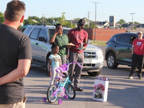 Carline Leslie-Ellis and Maurice Ellis and their four-year-old daughter Amara react after being gifted more than $6,700 through a scholarship and fundraiser from Dad Club London. The family received the money at a surprise gathering Monday night. (MEGAN STACEY/The London Free Press)