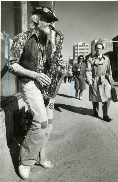 John Burnett plays his saxophone on Dundas Street, despite a warning he's contravening a city bylaw, 1988. (London Free Press files)