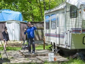 Krista Munro watches as Nathan Cordeiro cleans the couple's trailer at the Fanshawe Conservation Area in London, Ont. on Monday June 1, 2020. Trailer owners are now allowed to prepare their trailers for overnight stays that will begin next week. "We're glad to be back," said Munro."It feels like we've been waiting forever." (Derek Ruttan/The London Free Press)