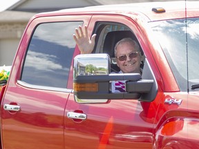 Ross Lunn waves from the passenger side of his truck as it parades around Iona, Wallacetown and Dutton-Dunwich on Sunday June 7, 2020. People lined the sides of roads holding large signs congratulating the 71-year-old on his recent release from hospital, where he spent more than 10 weeks fighting COVID-19. Derek Ruttan/The London Free Press/Postmedia Network