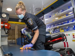 Middlesex-London paramedic Tara Cressman gives her ambulance a thorough cleaning after unloading a patient in London Tuesday. A report to councils outlines the pressures the paramedic service is under as its costs soar. (Derek Ruttan/The London Free Press)