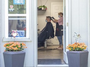 Nikolina Ristic gives a haircut to Srdjan Djukic at her home business, Nikolina Hair Design, in London on Friday June 12, 2020. (Derek Ruttan/The London Free Press)