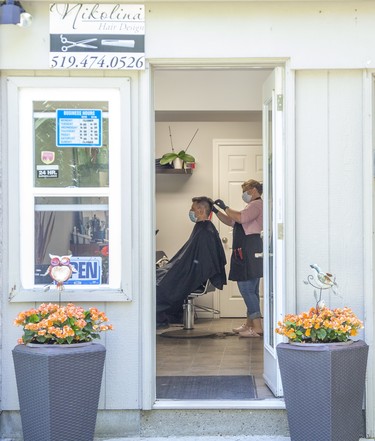 Nikolina Ristic gives a haircut to Srdjan Djukic at her home business, Nikolina Hair Design, in London, Ont. on Friday June 12, 2020. "Finally after all this time," he said. "I kept calling Nikolina (over the last three months) to tell her I want to be the first one when she opens. It feels amazing." Derek Ruttan/The London Free Press/Postmedia Network