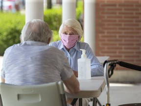 Betty Morris visits with her husband Victor outside of the McCormick Home where Victor resides in London, Ont. on Thursday. (Derek Ruttan/The London Free Press)