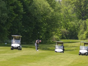 Joel Senese hits his approach on the 18th hole Tuesday, June 2, 2020 as his buddies, each in their own cart, wait on the fairway at the Thames Valley Golf Course. Golf courses are full as people take the opportunity for some outdoor activity. (Mike Hensen/The London Free Press)