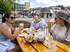 Zoe Daviault, Tristan Relouw and Jaclyn Skinner enjoy their afternoon food and beverages on the Barney's patio in London on June 16, 2020. (Mike Hensen/The London Free Press)
