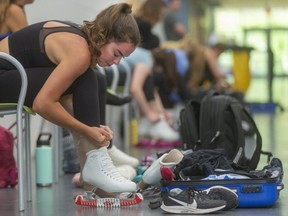 Evelyn Walsh, 19, of London, part of the second-ranked Canadian senior pairs team, laces her figure skates before a training session at the Komoka Wellness Centre in June. (Mike Hensen/The London Free Press)