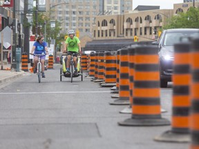 Cycling advocates Shelley Carr and Wesley Hill were quick to try out London's newest bike lane, running from Mill Street to Kent Street along Richmond Row in what is usually the southbound lane of vehicle traffic on the busy downtown London roadway.   (Mike Hensen/The London Free Press)