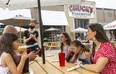 Miguel Cuellar, left, and his wife Natalia Gomez, right, put in their order with Emily Dobbin, a server at Chuck's Roadhouse on Richmond Street in downtown London. The family took their three daughters out for lunch to celebrate the graduation of their eldest Maria, 14, from Grade 8. Left is Antonia, 6, and drinking the soda is Silvana, 8. Mike Hensen/The London Free Press/Postmedia Network