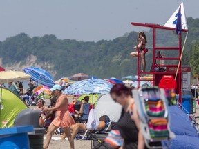 The beach at Port Stanley was busy, but not overly so, on Monday, June 29. Though it may not look like it in this image, compressed by being taken through a long lens, most groups were maintaining social distancing. (Mike Hensen/The London Free Press)