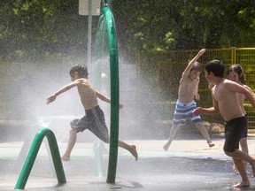 Liam Douthwright, 6, leads cousins and siblings through the splash pad in Gibbons Park in London on June 29, 2020.  (Mike Hensen/The London Free Press)