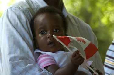 CANADA DAY 2010:   Belinda Karabo, 11 months old, listened to the national anthem in the arms of her father Joseph during an African celebration on Canada Day at Springbank Park. (Sue Reeve/The London Free Press)