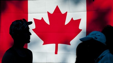 CANADA DAY 2012: People are silhouetted against  a Maple Leaf flag as they walk through Harris Park during Canada Day celebrations in London on Sunday July 1, 2012. CRAIG GLOVER The London Free Press
