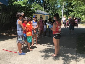 A lifeguard checks in a family for the first recreational swim of the season at the Thames Park Community Pool Saturday July 4. Swimmers had to reserve a spot in advance and are screened for COVID-19 before entering the facility. (Jennifer Bieman/The London Free Press)