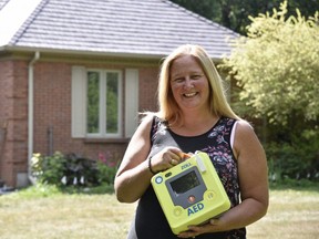 Cara Schmidt, the driving force behind Andrew’s Legacy, holds an automated external defibrillator (AED) at her Thamesford home. Last week the Thames Valley District school board approved funding for the last 42 AEDs needed for its schools, a campaign Schmidt started after her son Andrew died of a heart attack on an Oxford County soccer field. (Kathleen Saylors/Postmedia News
