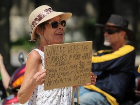 Carole Johnson from Sarnia holds up a sign during a protest against Sarnia’s mandatory mask bylaw on Thursday July 30, 2020 in Sarnia, Ont. (Terry Bridge/Postmedia Network)